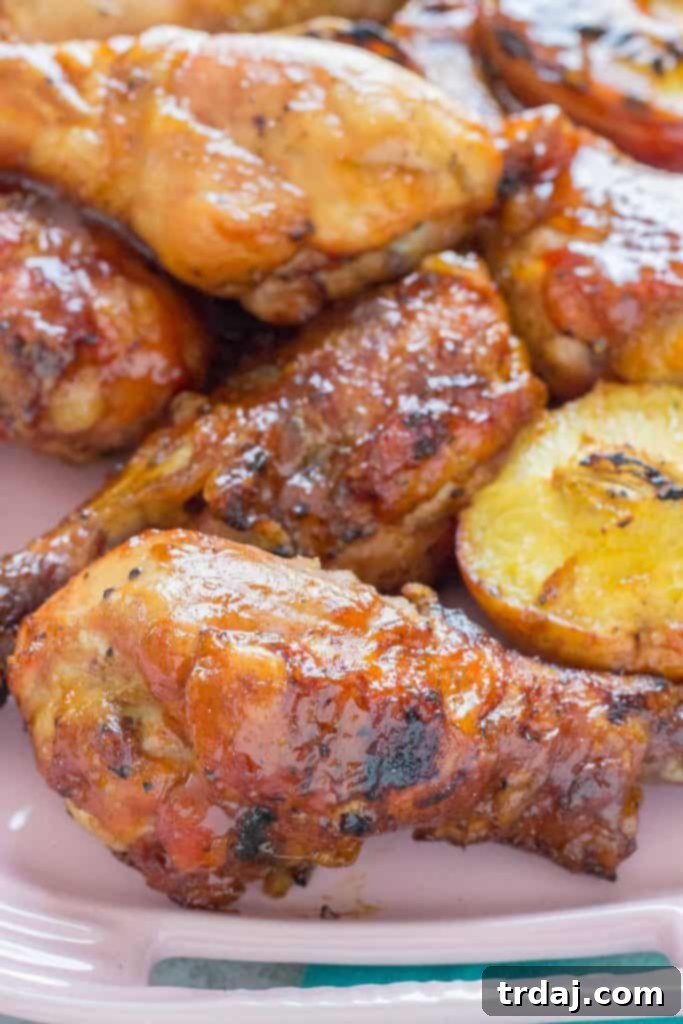 Grilled BBQ Peach Ginger Glazed Chicken Legs beautifully arranged on a serving plate.