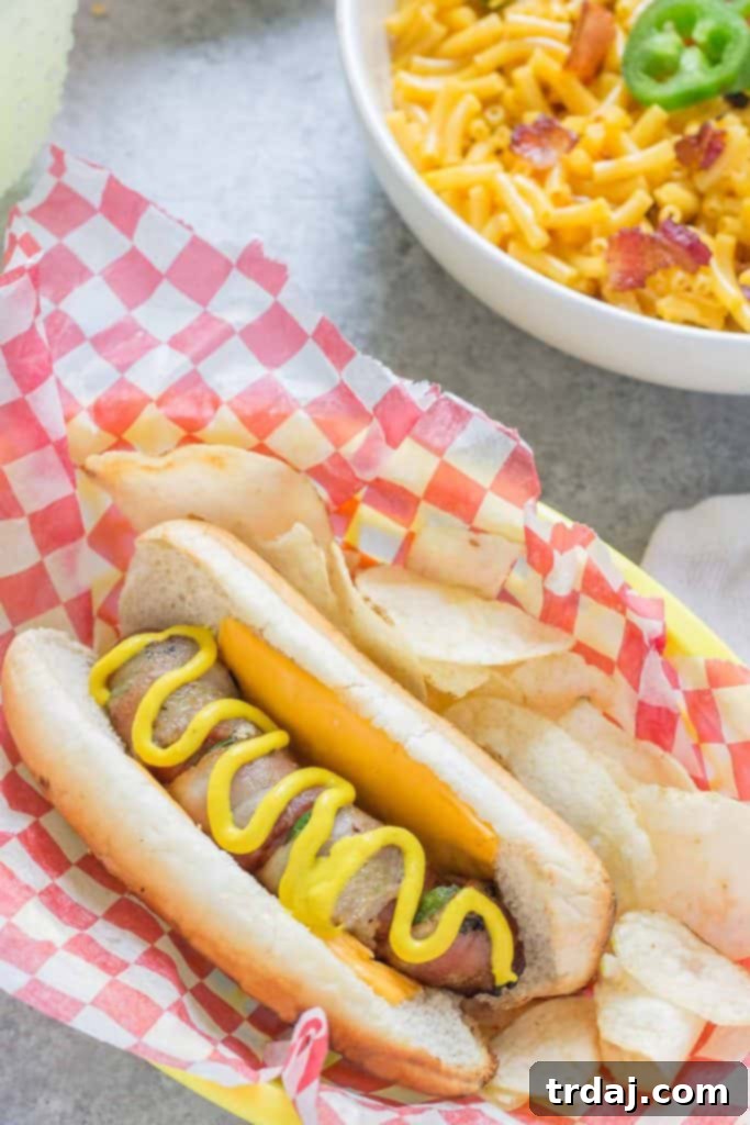 Two grilled Jalapeño Bacon Grilled Cheese Hot Dogs on a wooden cutting board