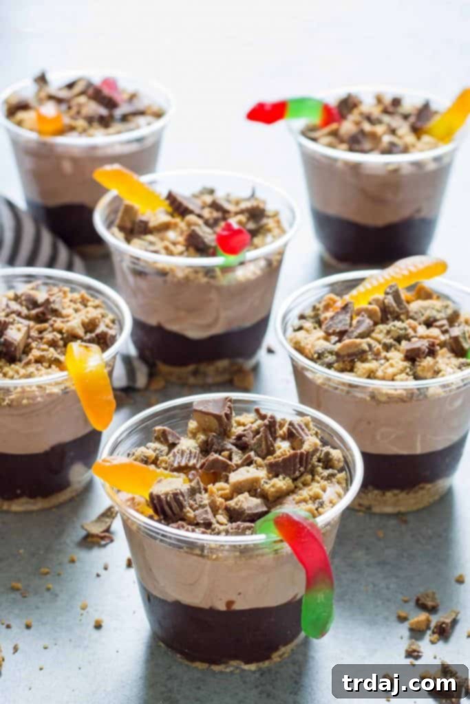 Stacked individual Peanut Butter Dirt Cups, garnished with gummy worms, ready for a party