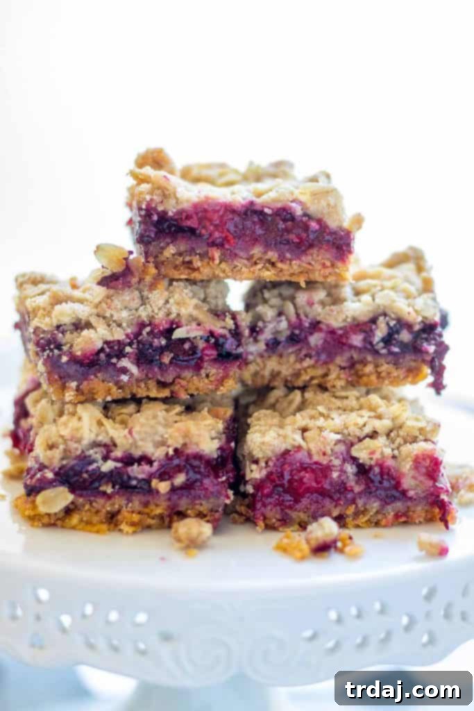 Close-up of Mixed Berry Crumble Bars showing distinct layers of crunchy crust, juicy berries, and a golden crumble topping.