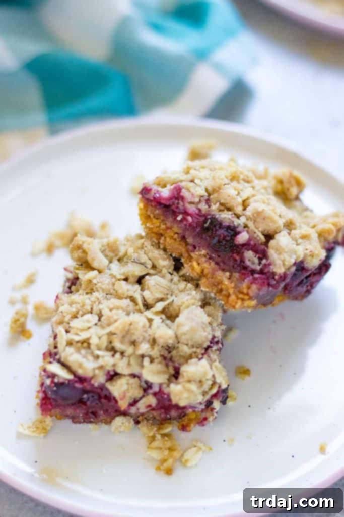 Freshly baked Mixed Berry Crumble Bars cooling on a wire rack, highlighting the golden crust and vibrant berry filling.