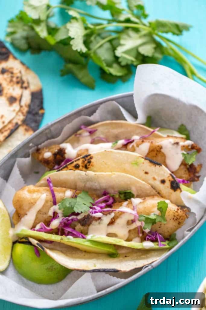 Ingredients for Spicy Baja Fish Tacos laid out including fish, avocado, and cabbage