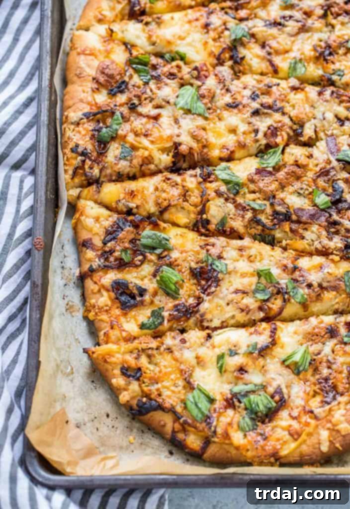 A close-up of Apple, Bacon and Caramelized Onion Pizza showing melted cheese, crispy bacon, and tender apple slices, a perfect blend of sweet and savory.