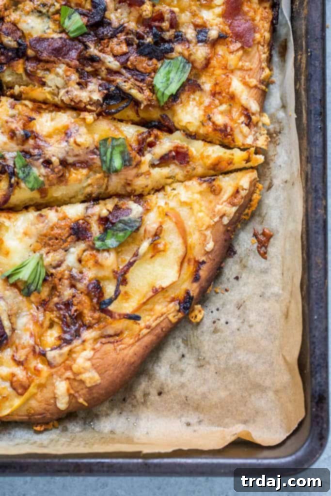 A whole Apple, Bacon and Caramelized Onion Pizza fresh from the oven, showcasing a golden crust, melted cheese, and vibrant toppings.