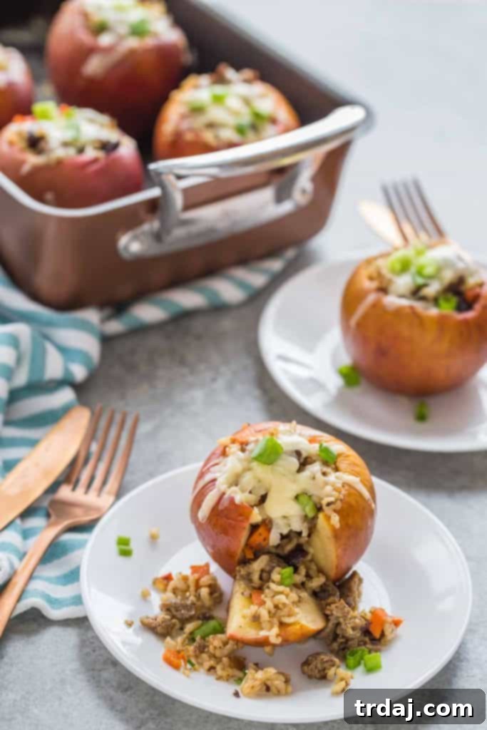 Close-up of a halved Stuffed Apple with Cheddar and Sausage, revealing the rich filling and golden-brown skin