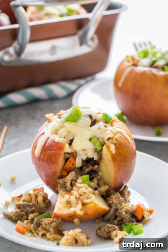 Stuffed Apples with Cheddar and Sausage, elegantly plated and garnished with fresh herbs