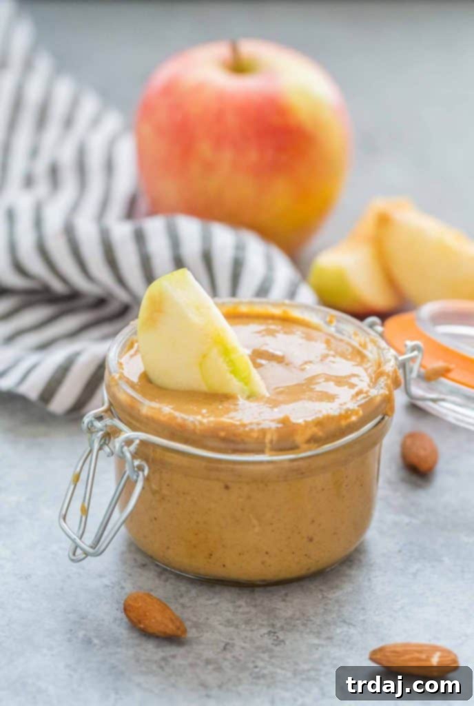 Aromatic spices combine with almonds to create a delicious Apple Chai Almond Butter that's perfectly spreadable on anything from apples to bread and everything in between! Homemade Apple Chai Almond Butter spread on an apple slice
