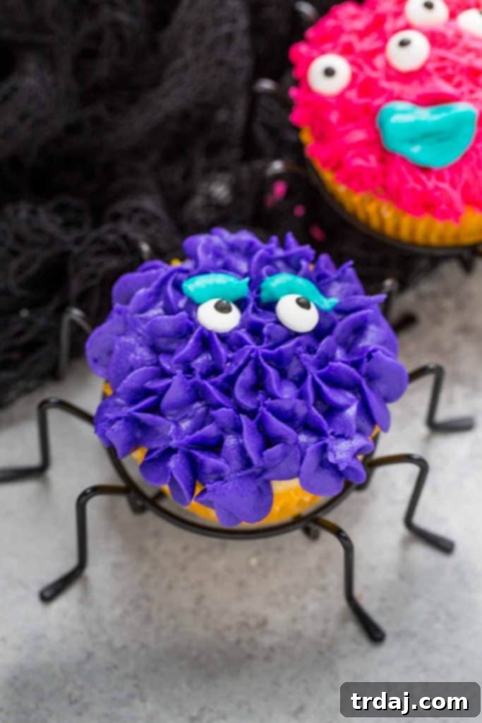 Close-up of a decorated Monster Pinata Cupcake, showing the colorful frosting and candy eyeball