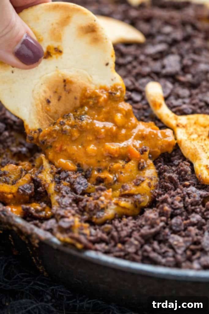 Graveyard Chorizo Dip is full of chorizo, beans, RO*TEL® and cheese. Topped with crushed chips to look like dirt and served with homemade Halloween tortilla chips, it's perfect for all those spooky parties! Graveyard Chorizo Dip