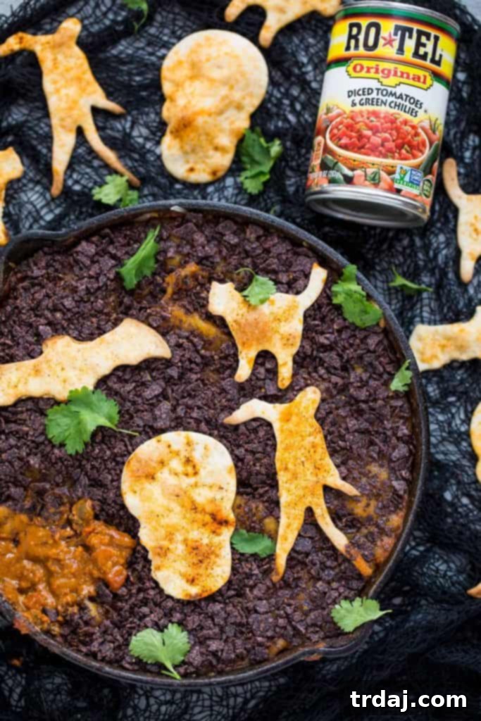 Graveyard Chorizo Dip is full of chorizo, beans, RO*TEL® and cheese. Topped with crushed chips to look like dirt and served with homemade Halloween tortilla chips, it's perfect for all those spooky parties! Graveyard Chorizo Dip