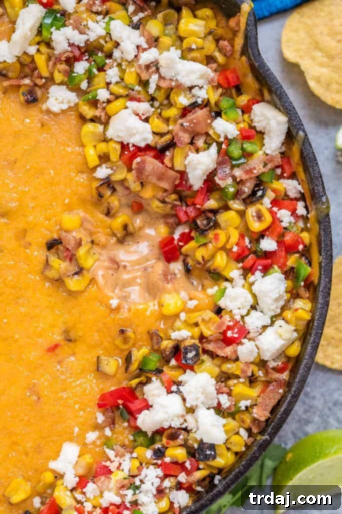 Serving Mexican Street Corn Queso with tortilla chips and fresh cilantro garnish