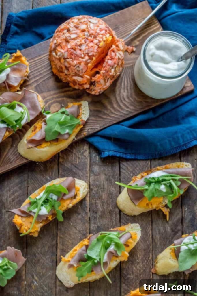 Assembling Roast Beef Crostini with toasted baguette, Kaukauna Port Wine Cheese Ball, roast beef, and horseradish cream