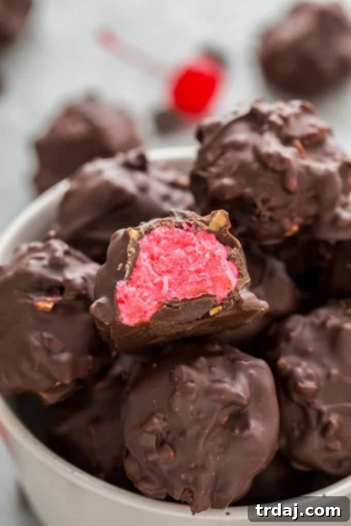Close-up of a Cherry Mash Truffle cut in half, revealing its hot pink center
