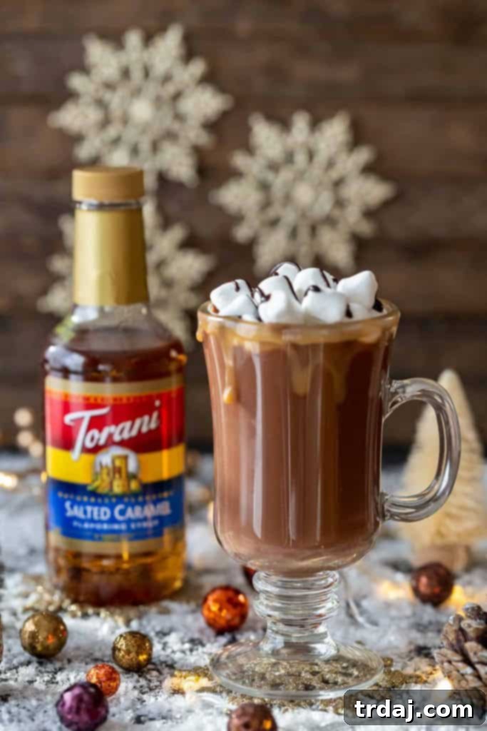 Ingredients for Salted Caramel Hot Chocolate Toddy laid out: milk, chocolate chips, Torani Salted Caramel syrup, and mugs ready for preparation