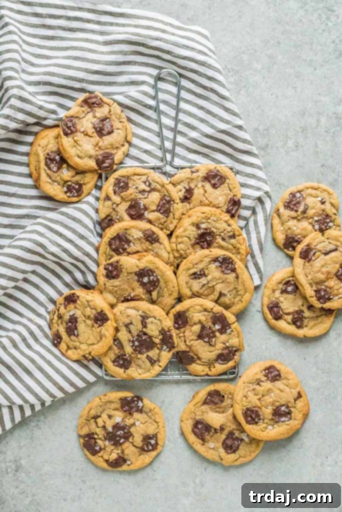 Close-up of a Tahini Toffee Chocolate Chip Cookie with a bite taken out, revealing its soft interior