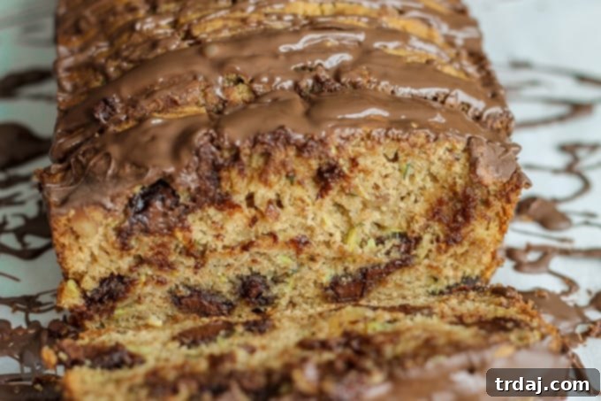 A close-up of a generous slice of Chocolate Chunk Zucchini Bread, revealing the melty chocolate chunks and moist crumb.