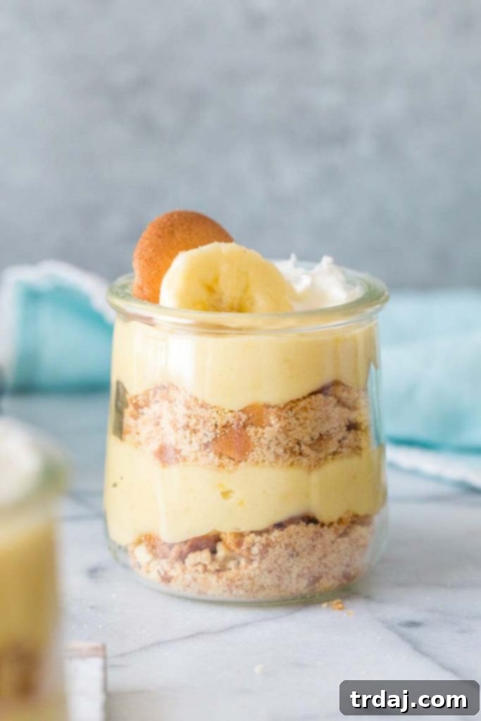 Classic Banana Pudding Parfaits, layered with homemade banana pudding, vanilla wafers, and whipped cream, served in a glass jar.
