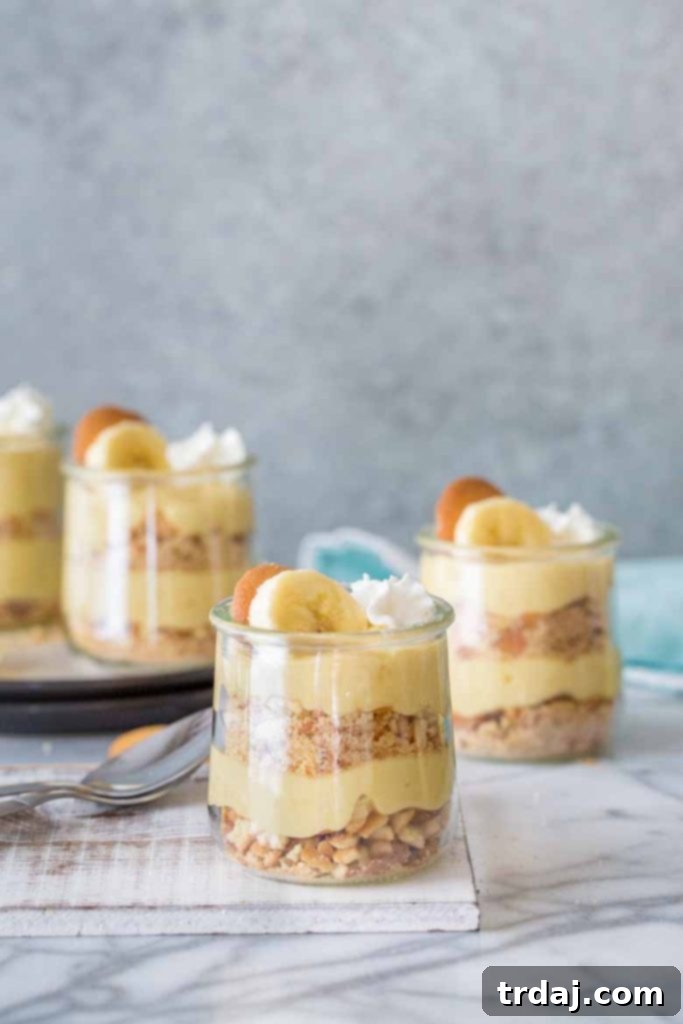 Classic Banana Pudding Parfaits in a clear jar, showcasing delicious layers of pudding, cookies, and cream.