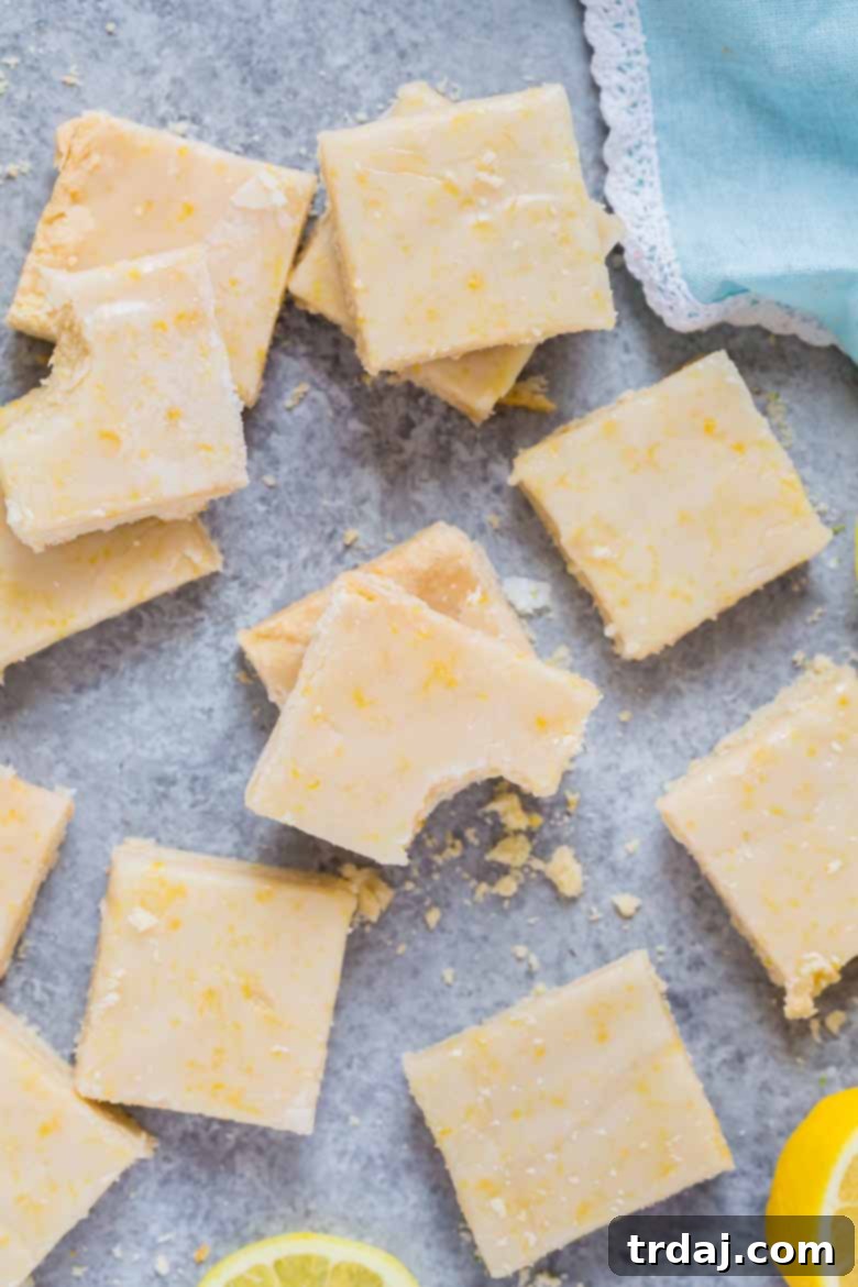 These Lemon Shortbread Bars are buttery and bursting with bright and fresh lemon flavors! Lemon Shortbread Bars on a plate with lemons