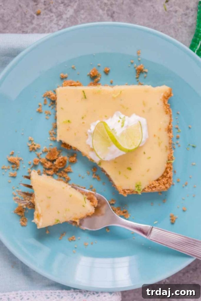 A perfectly sliced Sheet Pan Key Lime Pie, garnished with whipped cream and lime.