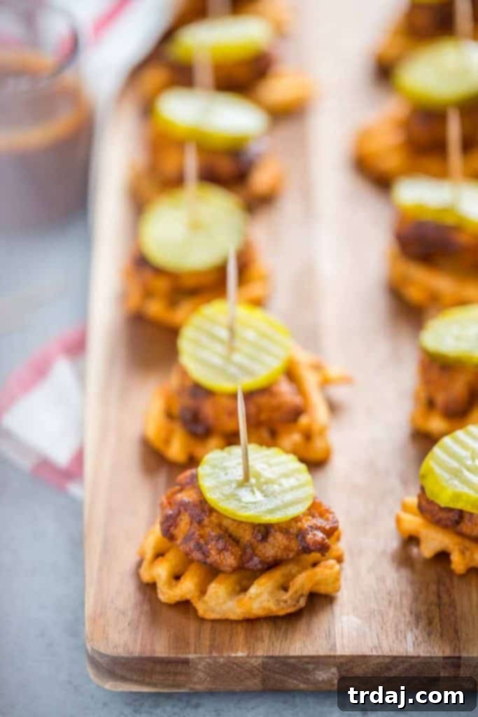 Nashville Hot Chicken Waffle Bites A perfectly assembled Nashville Hot Chicken Waffle Bite with pickle on a platter.