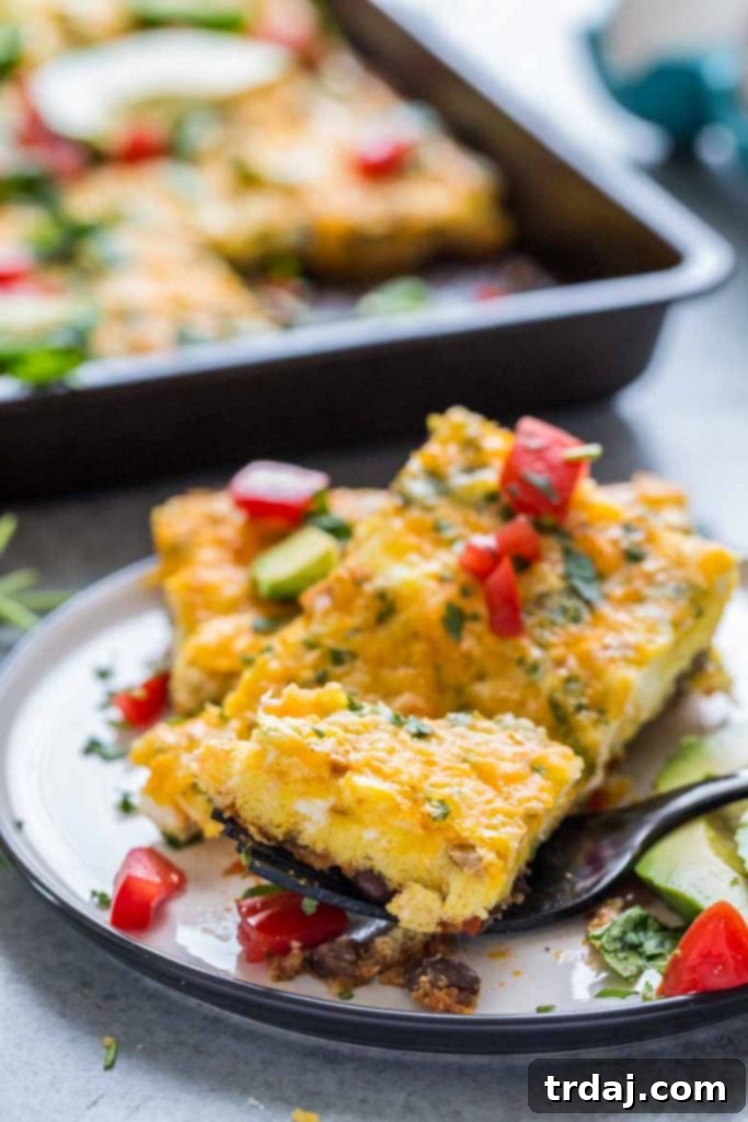 This Sheet Pan Mexican Frittata is packed full of delicious Mexican flavors and is perfect for a crowd or meal prep! Several slices of Sheet Pan Mexican Frittata on a serving board, garnished with fresh cilantro and avocado