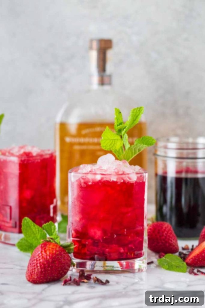 Ready-to-Enjoy Strawberry Hibiscus Mint Julep Finished Strawberry Hibiscus Mint Julep cocktail, garnished with fresh mint, showing the vibrant red color and refreshing appearance, ready to be enjoyed.