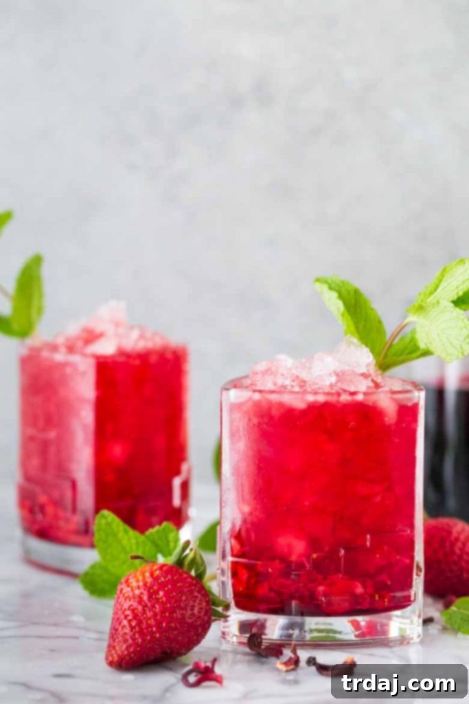 Mint Julep Variations and Serving Several Strawberry Hibiscus Mint Julep cocktails displayed on a table, highlighting their vibrant color, fresh garnishes, and the festive atmosphere they create.