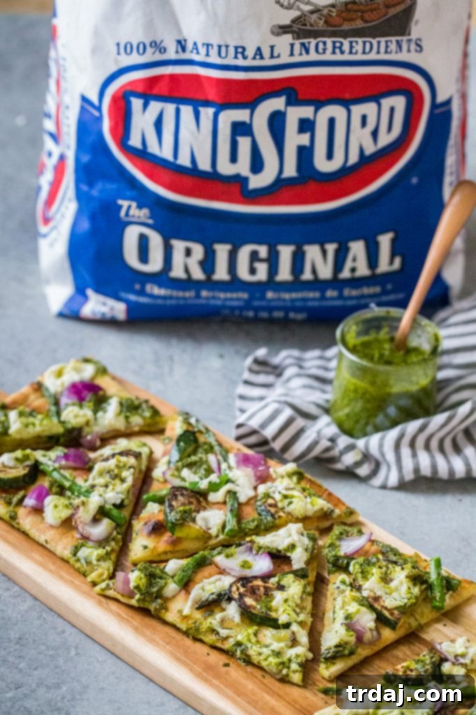 Close-up of a perfectly grilled vegetable flatbread, showcasing fresh ingredients.