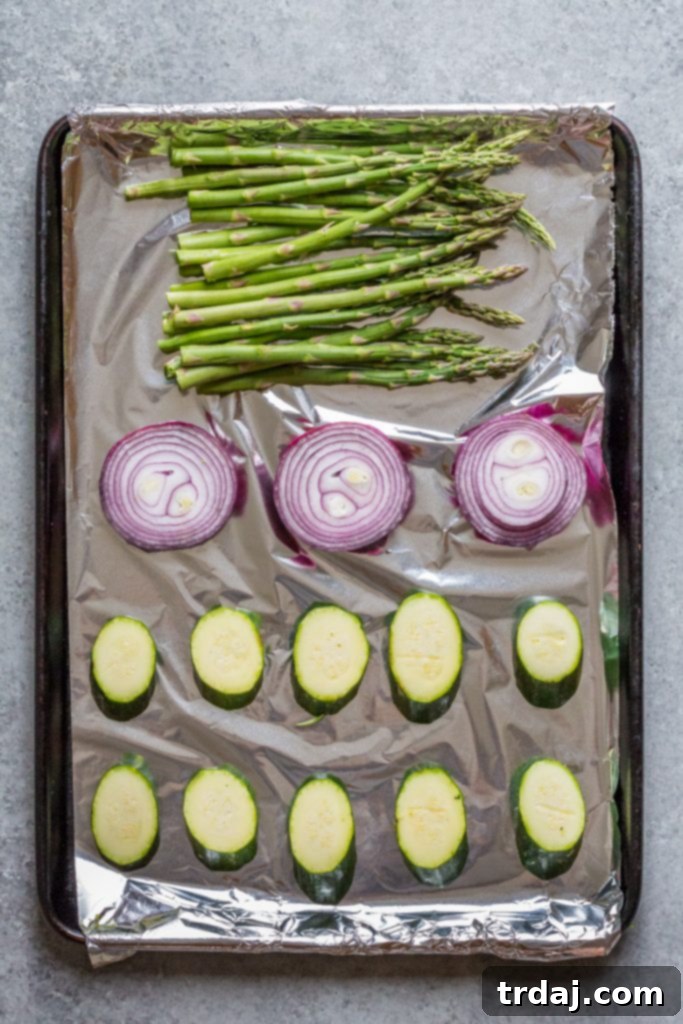 Sliced zucchini, red onion, and asparagus, seasoned and ready for the grill.