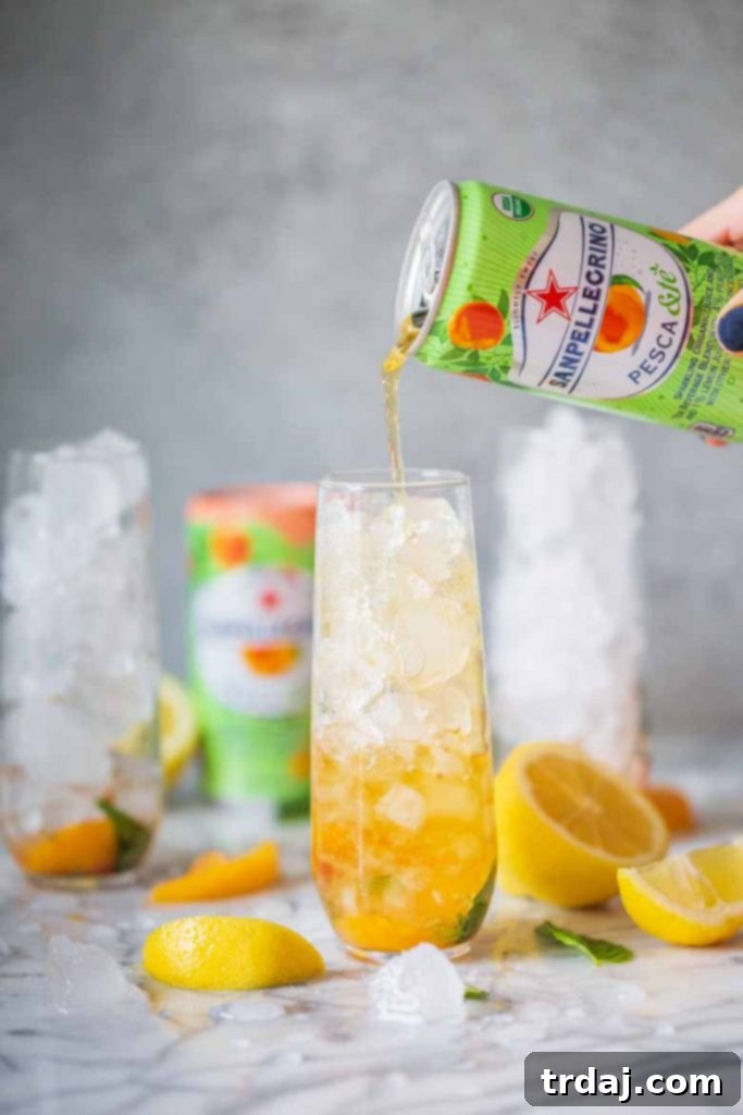 Pouring SANPELLEGRINO Pesca & Tè into the Peach Basil Mojito Mocktail