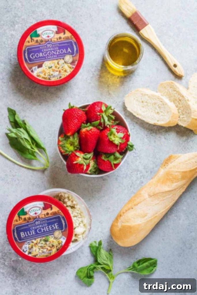 Ingredients laid out for Strawberry Blue Cheese Bruschetta: baguette, olive oil, strawberries, basil, and blue cheese
