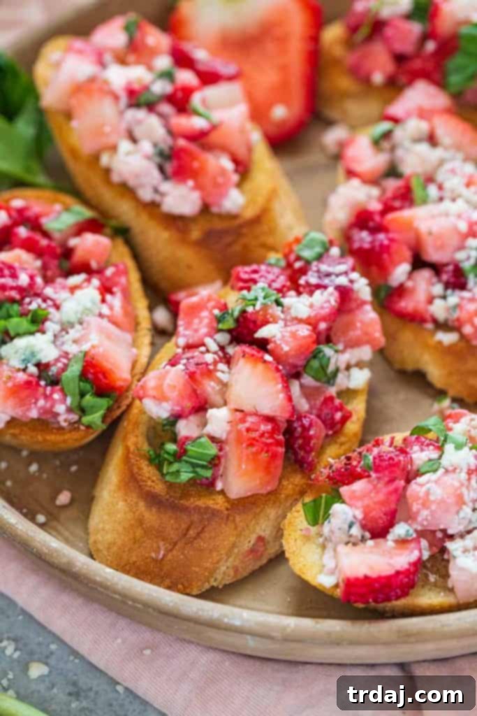 Strawberry Blue Cheese Bruschetta arranged on a platter with fresh basil