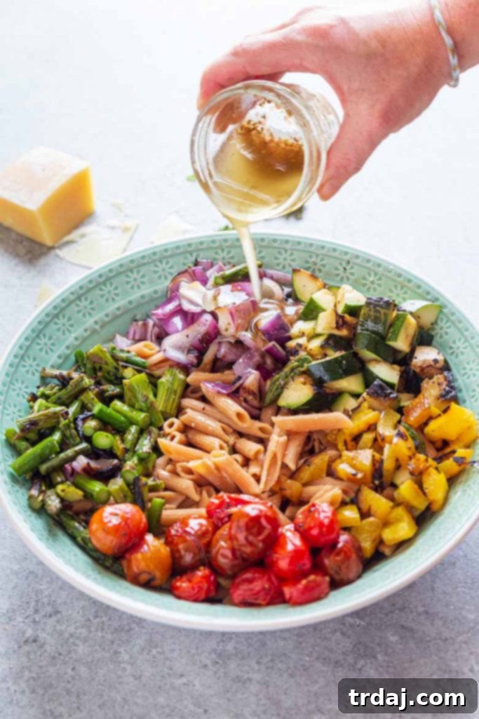 Drizzling pasta salad dressing onto grilled vegetables and pasta