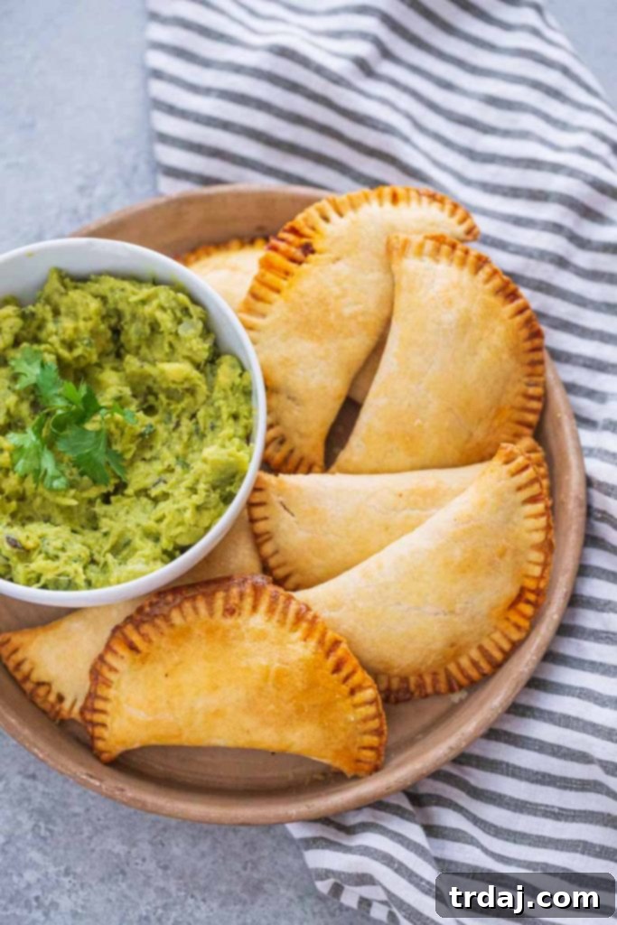 baked beef empanadas on a tray with guacamole