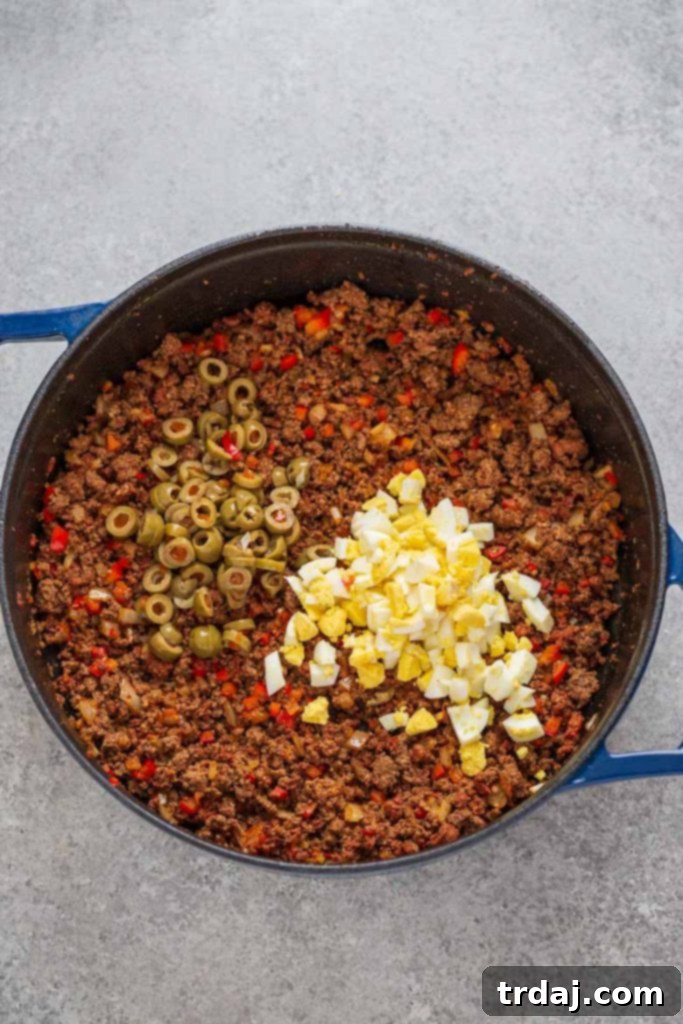 Beef and chorizo cooked with red bell pepper, onion and garlic, green olives and hard boiled eggs for baked beef empanadas