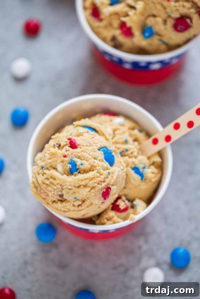 A bowl of Patriotic Edible Cookie Dough, featuring red, white, and blue M&M's and sprinkles, symbolizing a festive and safe dessert.