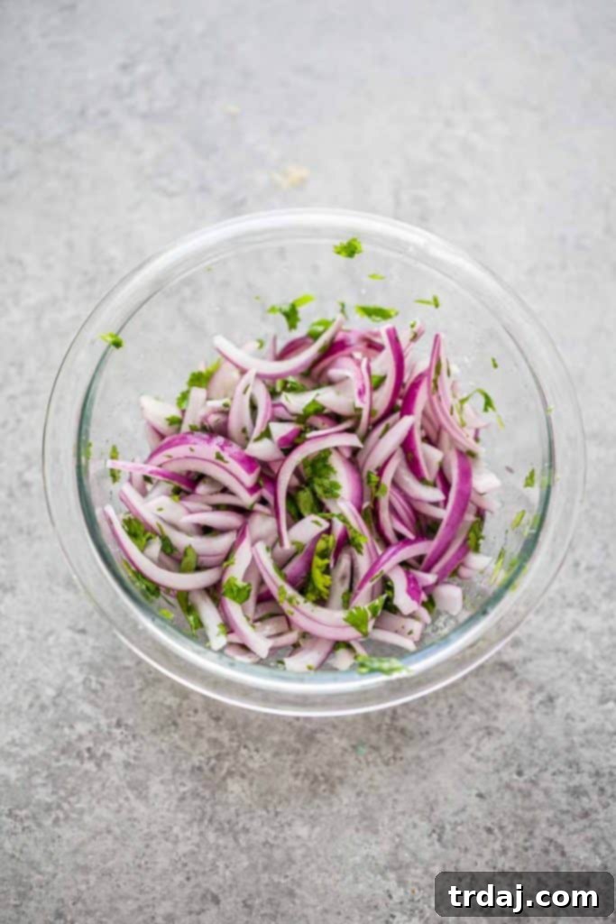 A bowl of freshly prepared pickled red onions with cilantro and lemon juice