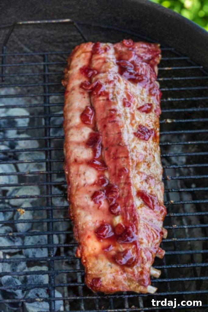 Watch your Cherry Pineapple Glazed Ribs achieve smoky perfection on the charcoal grill. Cherry Pineapple Glazed Ribs on a charcoal grill