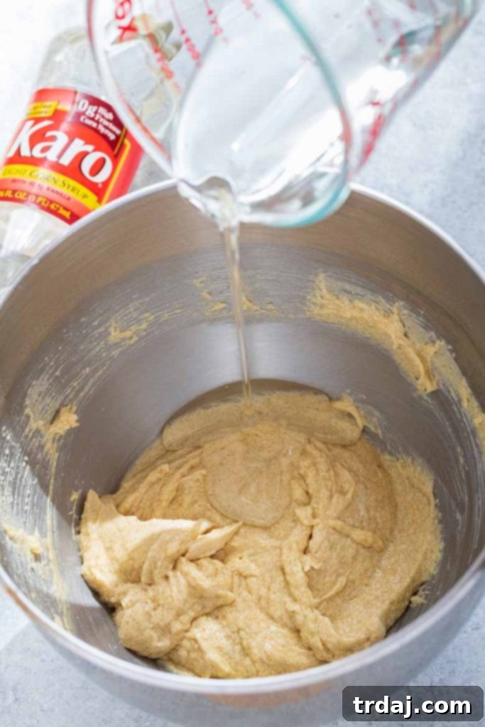 Adding Karo Corn syrup to the wet ingredients for Chewy Seven Layer Cookies.