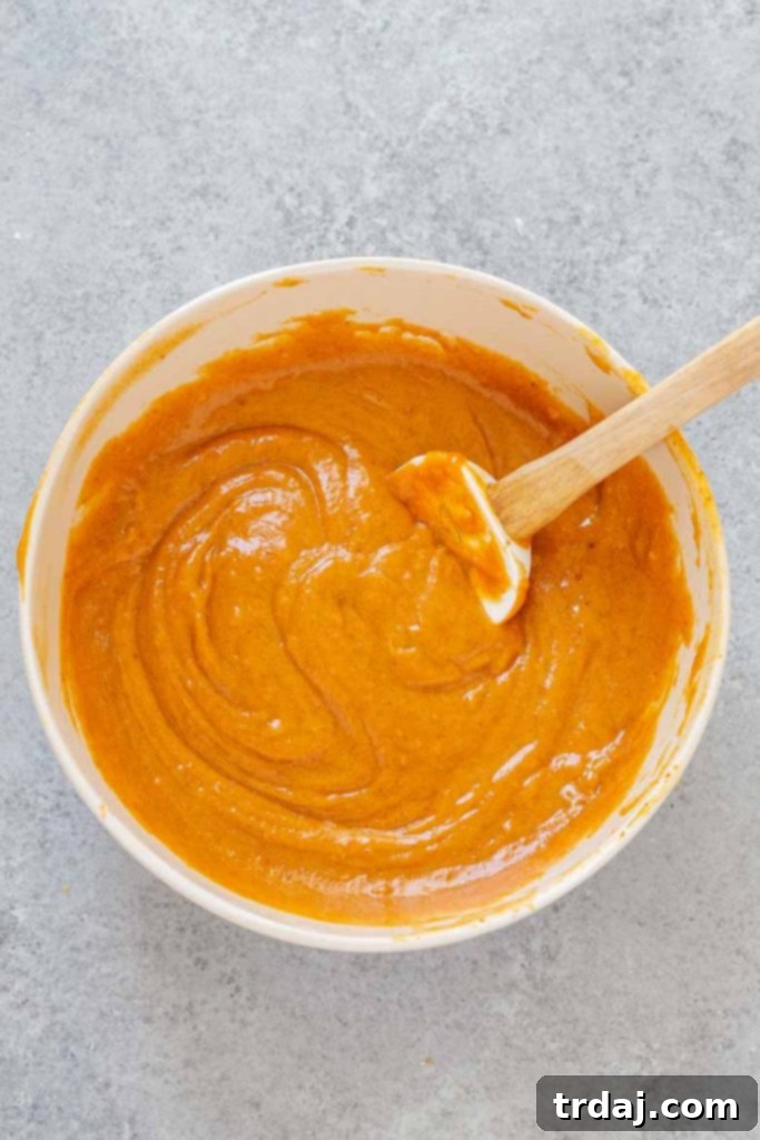Pumpkin bread batter in a mixing bowl, smooth and ready for the next step.
