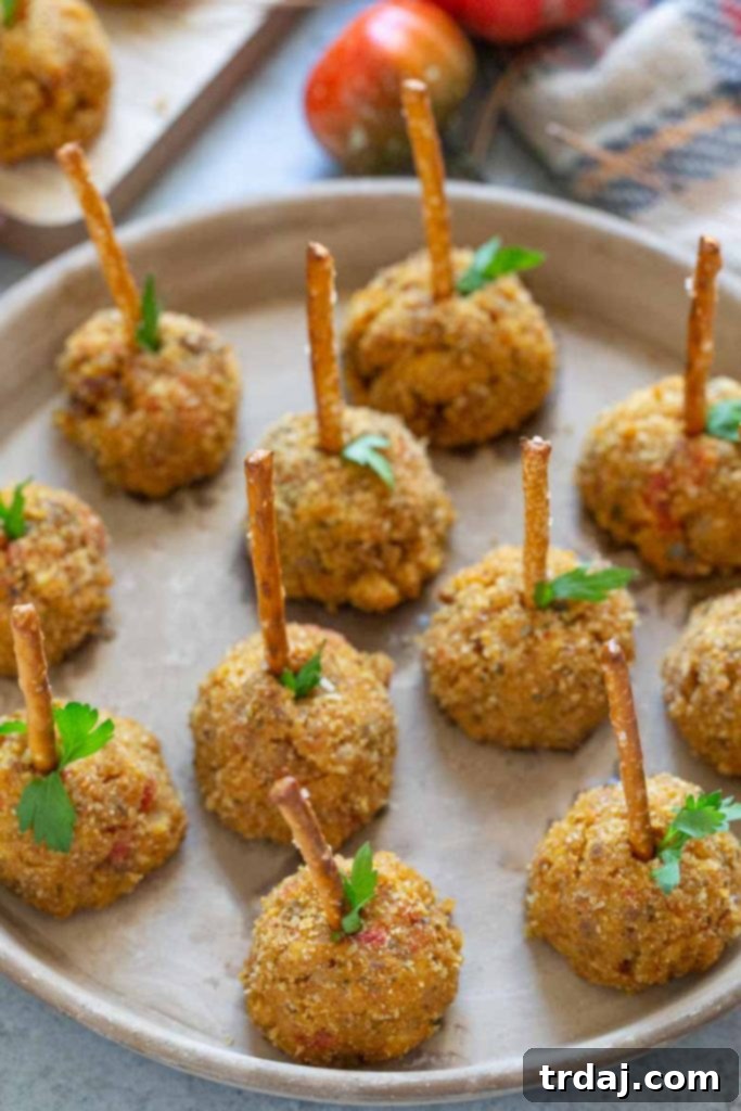 A plate of freshly baked Pumpkin Sausage Cheese Balls ready to be served, garnished with fresh parsley.