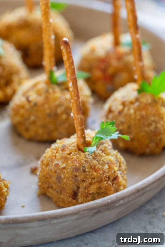 A festive display of Pumpkin Sausage Cheese Balls, garnished and ready for a holiday or seasonal gathering.