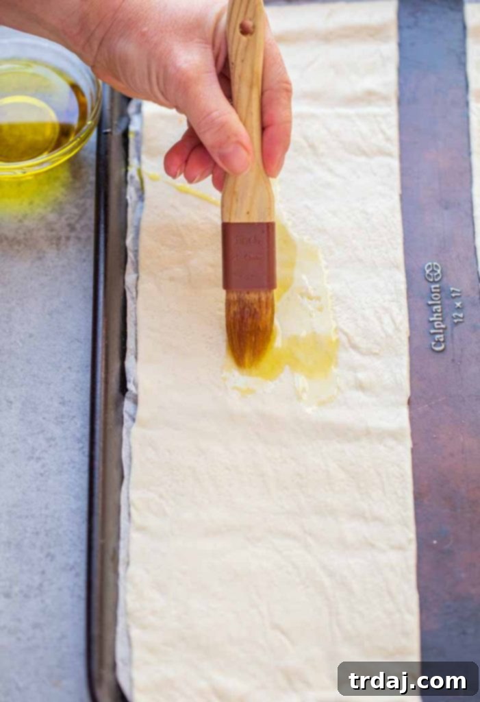 Brush oil onto pizza crust for Easy Margherita Flatbread Recipe