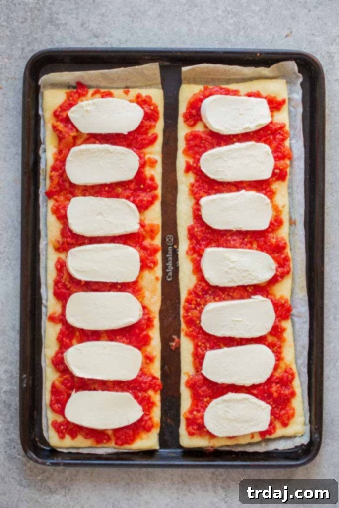 Place fresh mozzarella on top of crushed tomatoes on pizza crust