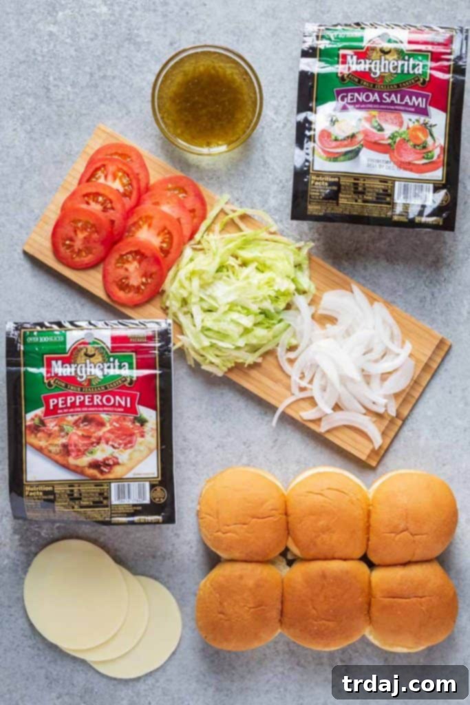 Freshly cut slider rolls laid open, ready for the layers of delicious Italian meats and cheeses.