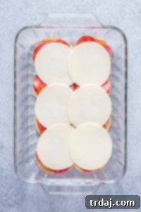 Adding fresh provolone cheese slices to the salami and pepperoni base of the sliders.