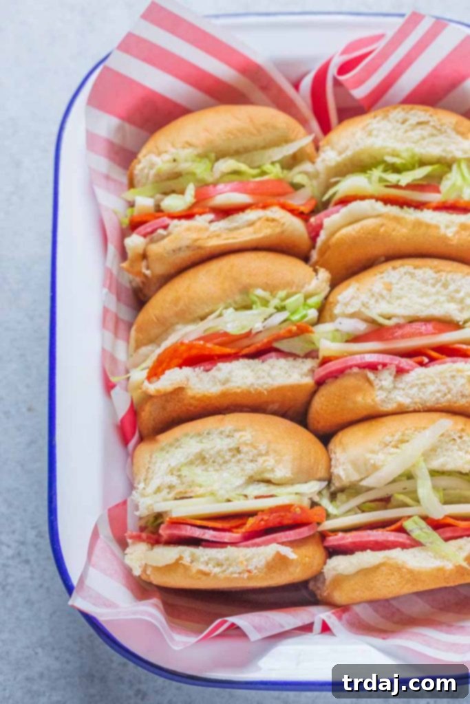 A beautifully arranged plate of Italian Sandwich Sliders, showcasing their colorful layers of meats, cheese, and fresh vegetables.