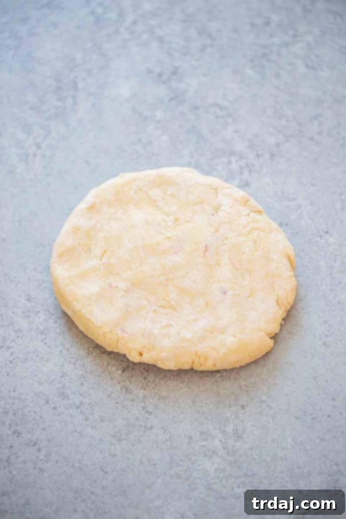 Mixing flour, butter, and cream cheese to form pecan tassie dough
