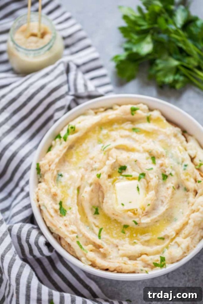 Close-up of a serving bowl filled with steaming, creamy Instant Pot Horseradish Mashed Potatoes, showcasing their luxurious texture.